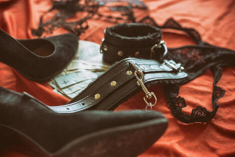 Black heels, cuffs, and panties on a background of red sheets. Learn more about BDSM and Kink from a sex therapist in Plymouth, MN via online therapy in Minnesota here. 55369 | 55361 | 55391