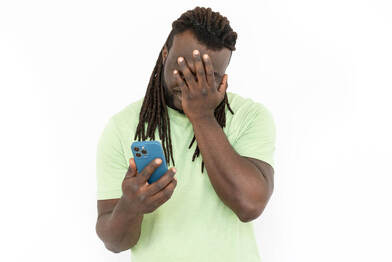 Picture of a man holding his face while looking at his phone. Ridiculous slang terms for sexual health and body parts are not suitable for proper sexual wellness. A Plymouth, MN sex therapist can help you near 55447 | 55441 | 55442