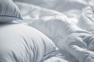 Close up photo of plush, white bedding. Couples in Minnesota can feel more comfortable and confident about their marriage with help from a professional sex therapist.