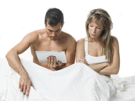 Picture of a couple in bed, looking at porn. Porn can impact relationships in many ways, including problematic porn use and out-of-control sexual behaviors in Minnesota. Online therapy in MN can be done with a sex therapist from Plymouth, MN. 55311 | 55305 | 55343