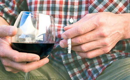 Picture of a man holding a glass of wine and a cigarette. Learn more from an online sex therapist in Minnesota here. We can talk about erectile dysfunction treatment Minneapolis, MN as well as Gottman couple therapy and more here.