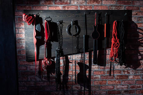 Picture of a rack of sex toys on an exposed brick wall. A Minnesota sex therapist can help you feel more connected to your partner via online sex therapy in Minnesota and more.