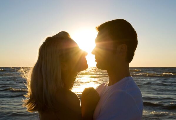 Couple embracing and talking about their sexual values at the beach with the sun behind. You can get sex therapy in Minnesota and counseling in Plymouth, MN for couples therapy, marriage counseling and sexual preferences. Get online therapy in Minnesota here too! 