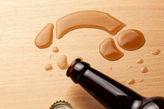Picture of a beer bottle neck with beer spilling into the shape of a penis on a wooden table. Learn more from an online sex therapist in Minnesota here. We can talk about erectile dysfunction treatment Minneapolis, MN as well. Learn more!