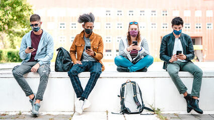 Picture of young adult singles on a ledge looking at their phones.  You can get open relationship counseling minneapolis, mn here with a skilled sex therapist or LGBT therapist in Plymouth, MN via online therapy in Minnesota.
