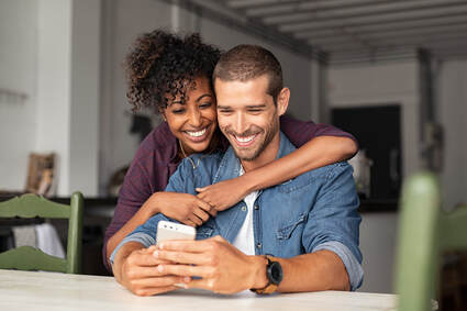 Picture of a couple in love, in their house looking at a phone. You can feel more comfortable and confident in bed with sex therapy in Plymouth, MN. Ed therapy in Plymouth, MN, Erectile dysfunction therapy in Plymouth, MN and Sex therapy in the Minneapolis area is available from a trained sex therapist at the Sexual Wellness Institute