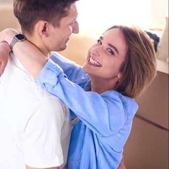 Woman and man smiling at each other, with woman smirking at the camera after discussing her desire for porn and masturbation. A skilled sex therapist in Minneapolis can help you connect with marriage counseling or couples therapy in Plymouth, MN via online therapy in Minnesota.