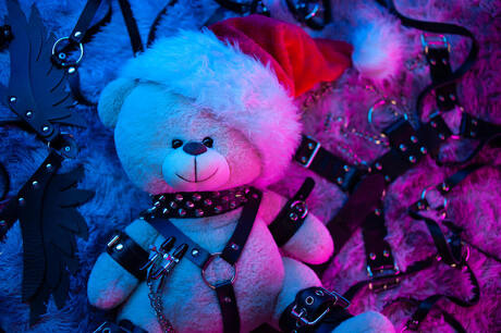 Picture of a bear with santa hat in BDSM gear with neon lighting. BDSM questions can be discussed with a sex therapist in Plymouth, MN via online sex therapy in Minnesota here.