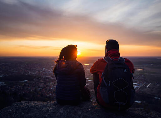 Couple sitting in the sunset overlooking the city. Couples therapy near Minneapolis, MN with a sex therapist in Plymouth, MN can help you explore your desires with online sex therapy in Minnesota.
