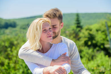 Couple embracing overlooking nature. Both look happy, relaxed and idealistic. Sex therapy for couples in Plymouth, MN can help you feel more connected. Online therapy in Minnesota can even include sex therapy online during COVID 19.