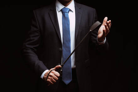 Man in a suit holding a whip, symbolizing a dominant or master in kink or BDSM. For sex therapy in Plymouth, MN or online sex therapy in Minnesota consider a sex therapist near Minneapolis. 55311 | 55305 | 55343