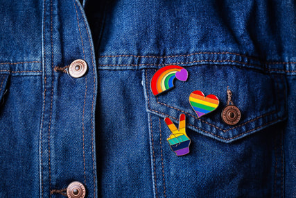 Picture of a jean jacket with PRIDE pins on it. Affirming therapists in Plymouth, MN can help via online therapy in Minnesota for LGBTQ+ individuals and couples. 55311 | 55305 | 55343
