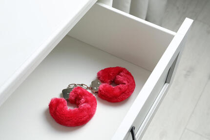 Picture of fluffy handcuffs in a white drawer. To spice up your sex life, talk with a sex therapist in couples therapy in Plymouth, MN or via online sex therapy in Minnesota with a professional sex therapist.